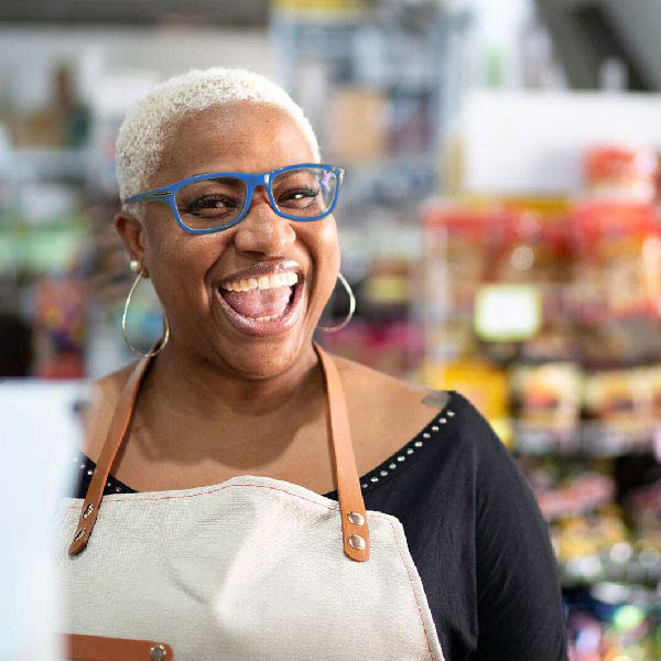 Woman in blue glasses smiling.